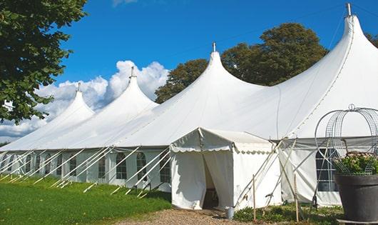 tall green portable restrooms assembled at a music festival, contributing to an organized and sanitary environment for guests in Newton